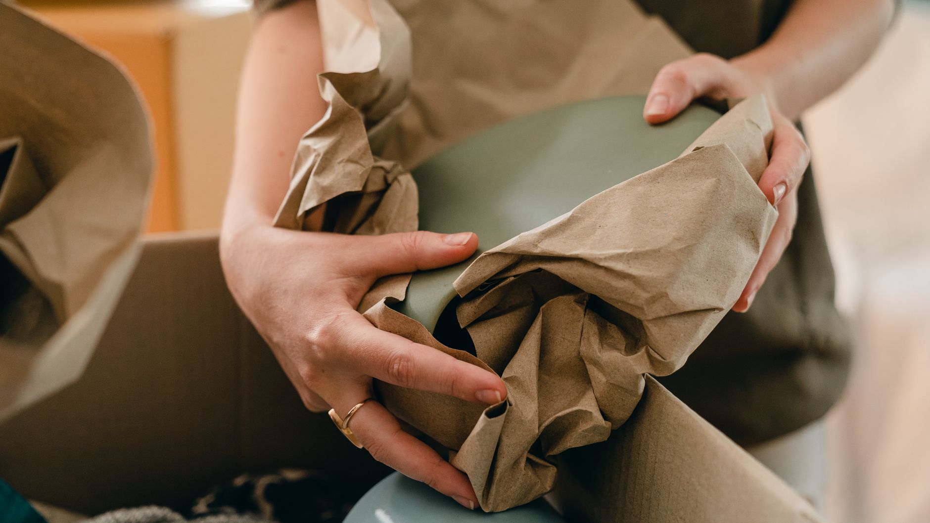 Crop anonymous young female wrapping fragile items in packing paper while preparing for relocation — Packing Problems? Why Pr
