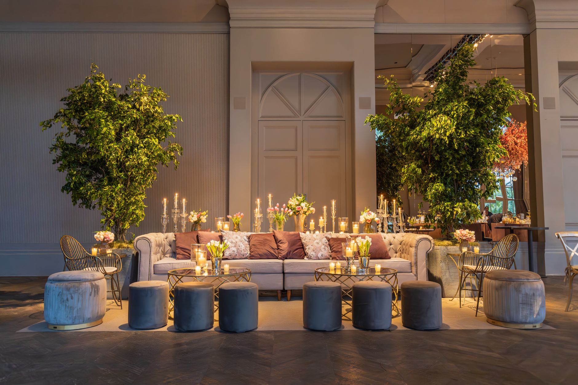 Stylish lounge setup with plush sofa, candles, and lush greenery indoors. — "The Advantages of Installing Glass Railings in W
