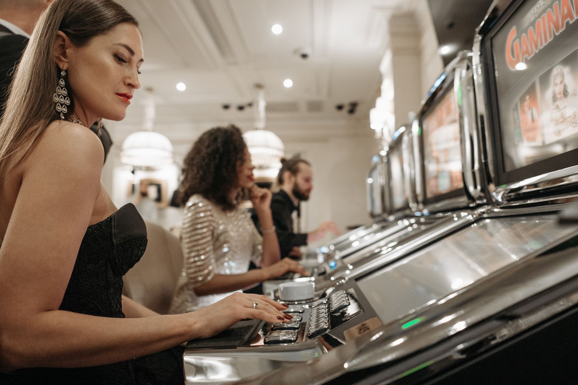Stylish women engage in casino gaming at slot machines, showcasing elegance and excitement. — The Evolution of Casino Gaming: