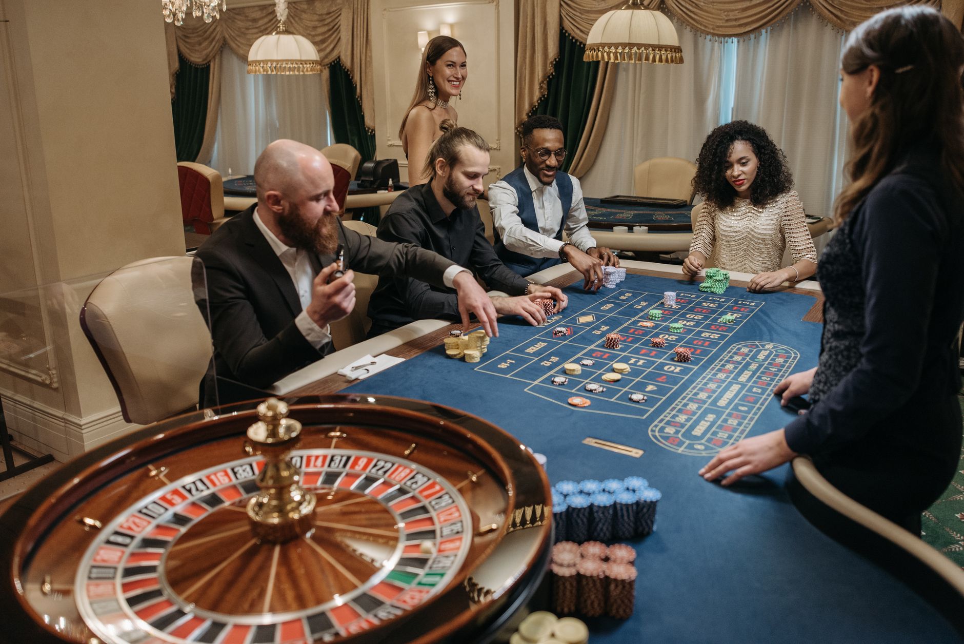 A lively casino scene with diverse people playing roulette at a gaming table. — The Future of Live Casino Gaming