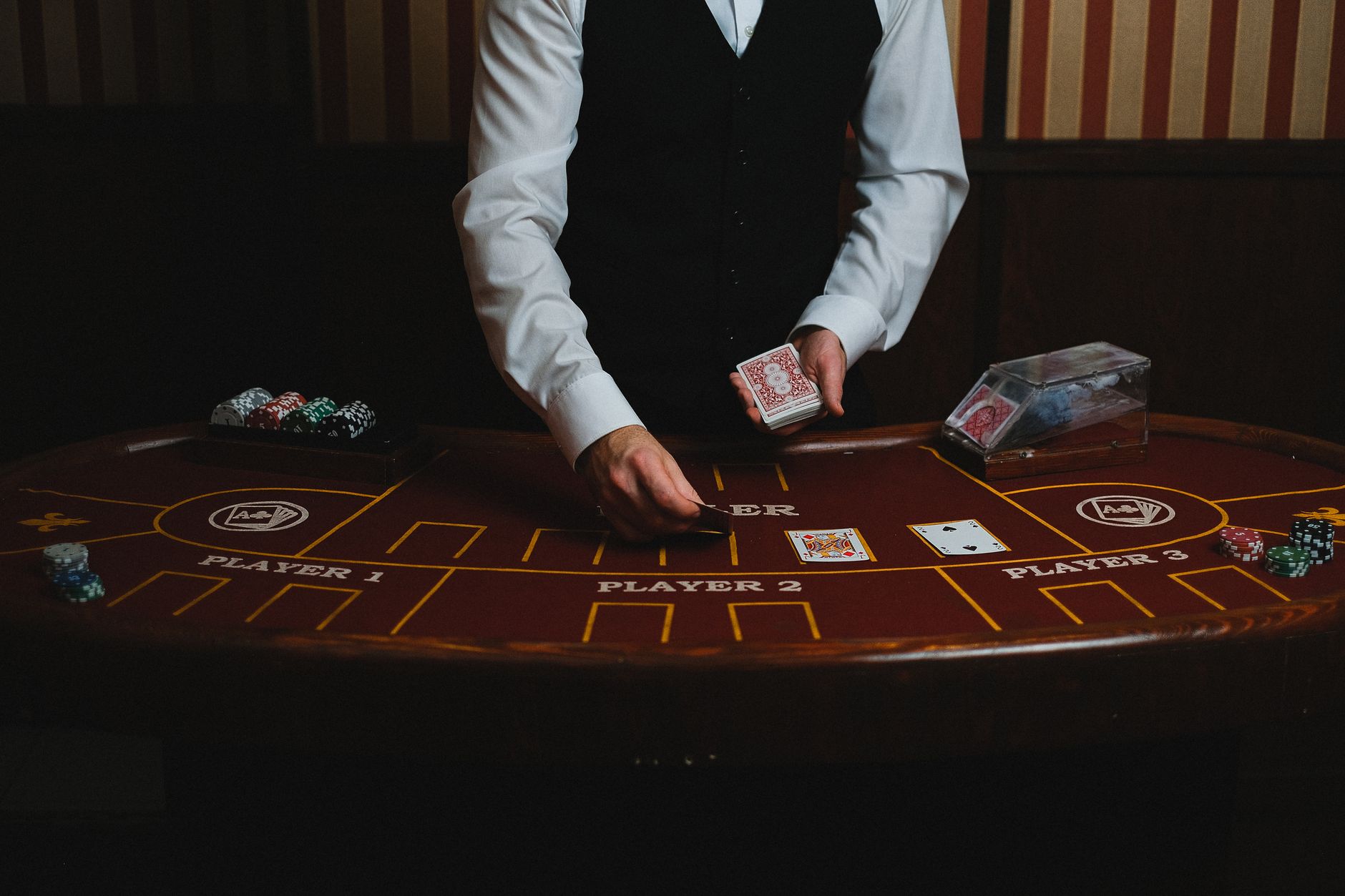 A casino dealer handling cards at a gaming table, ready for blackjack or poker. — The Future of Virtual Reality in Casinos