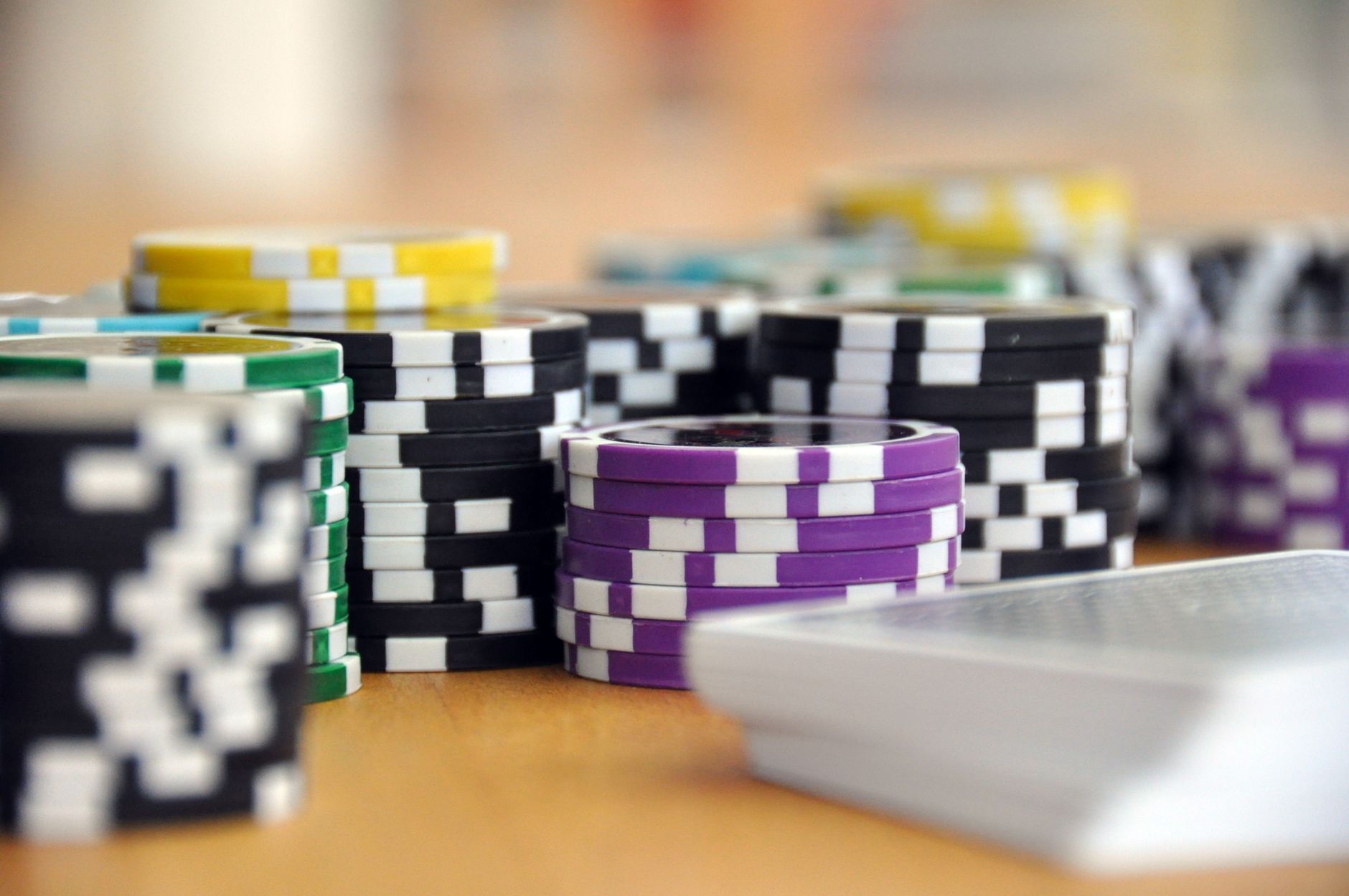 A close-up shot of stacked poker chips and playing cards on a table, perfect for casino and gambling themes. — The Impact of 