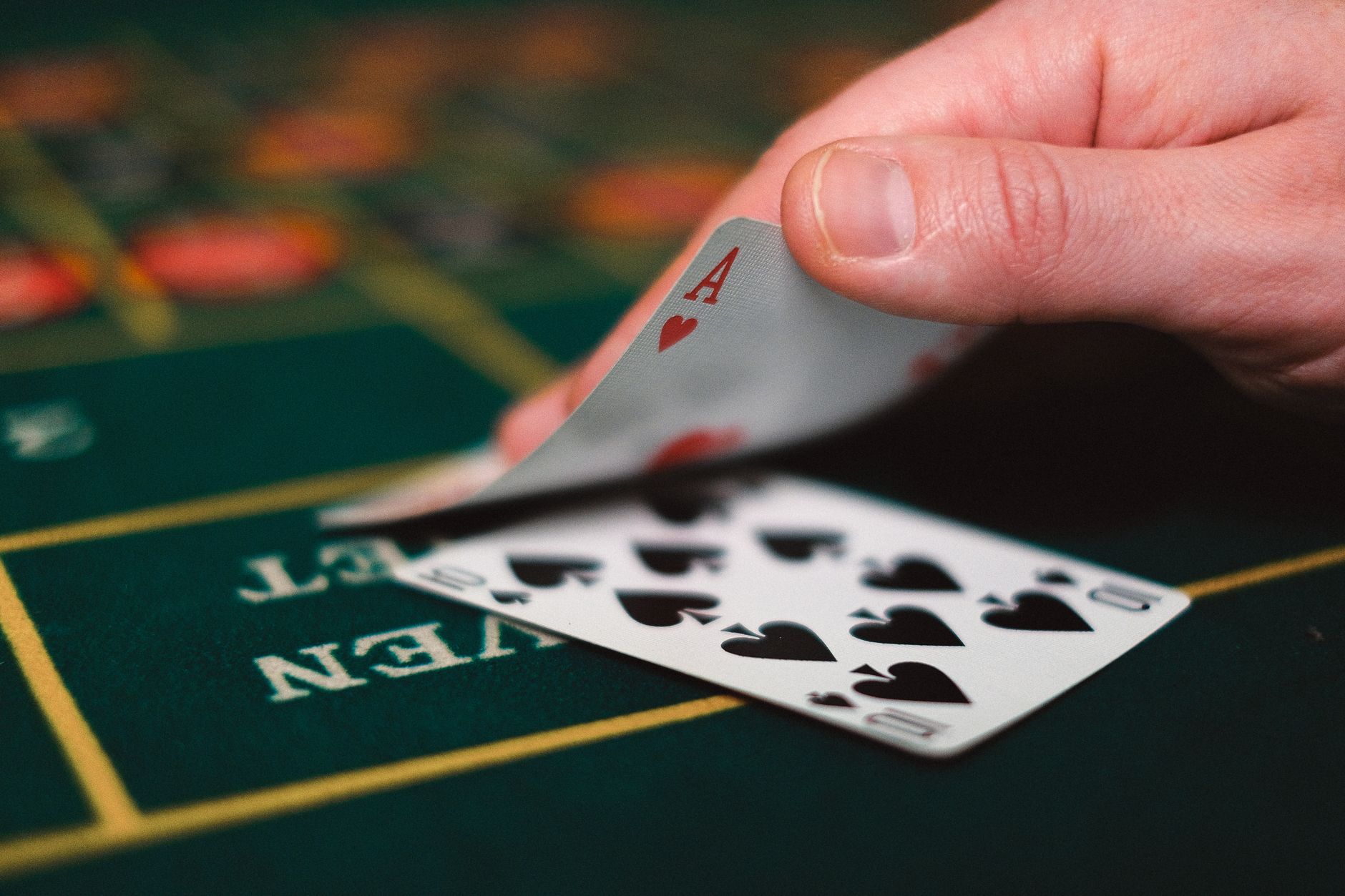 Close view of playing cards and hand on a casino table, capturing the gambling atmosphere. — The Rise of Esports Betting in C