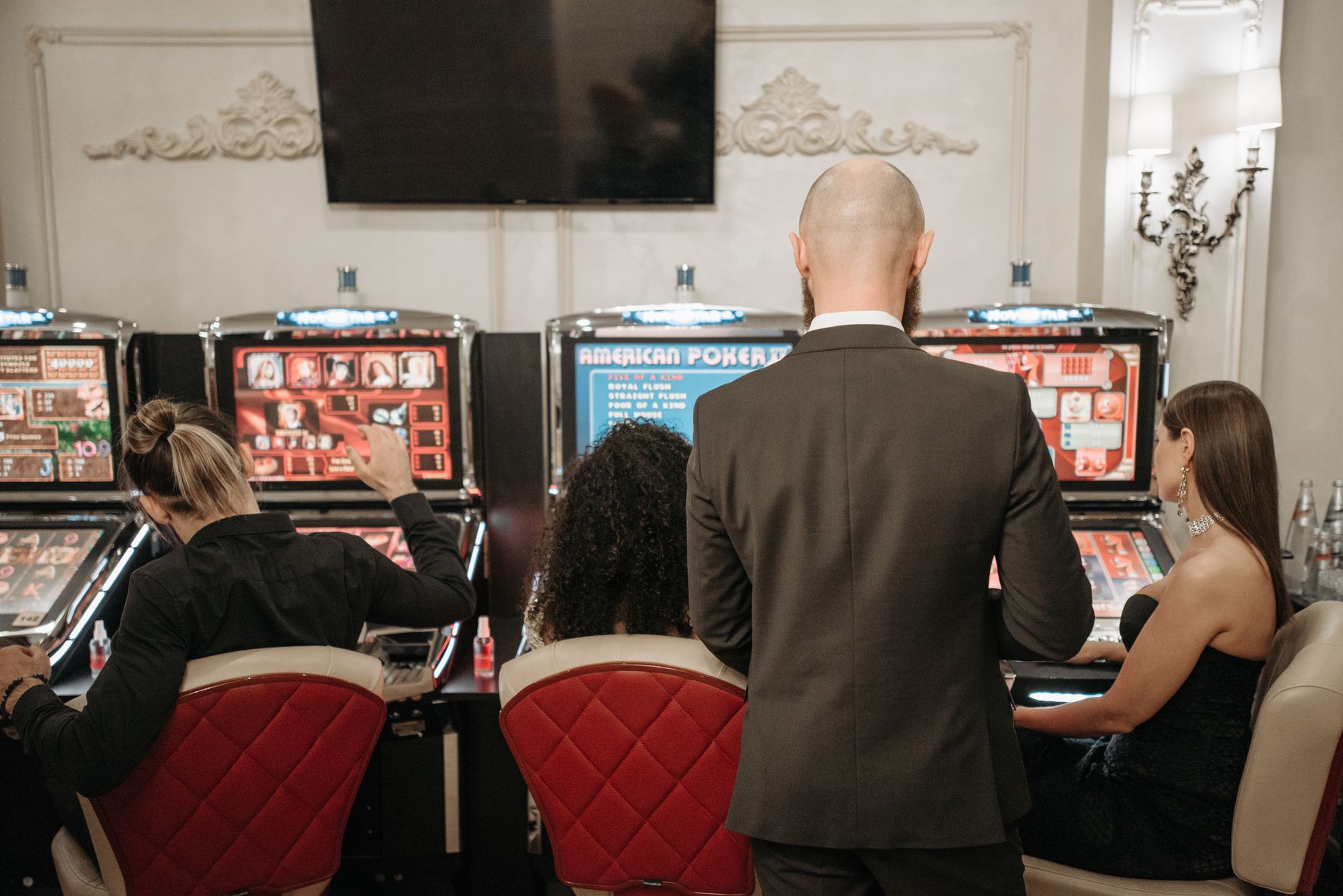 A group of adults engaged in playing slot machines inside a stylish casino setting. — The Rise of Live Dealer Casinos