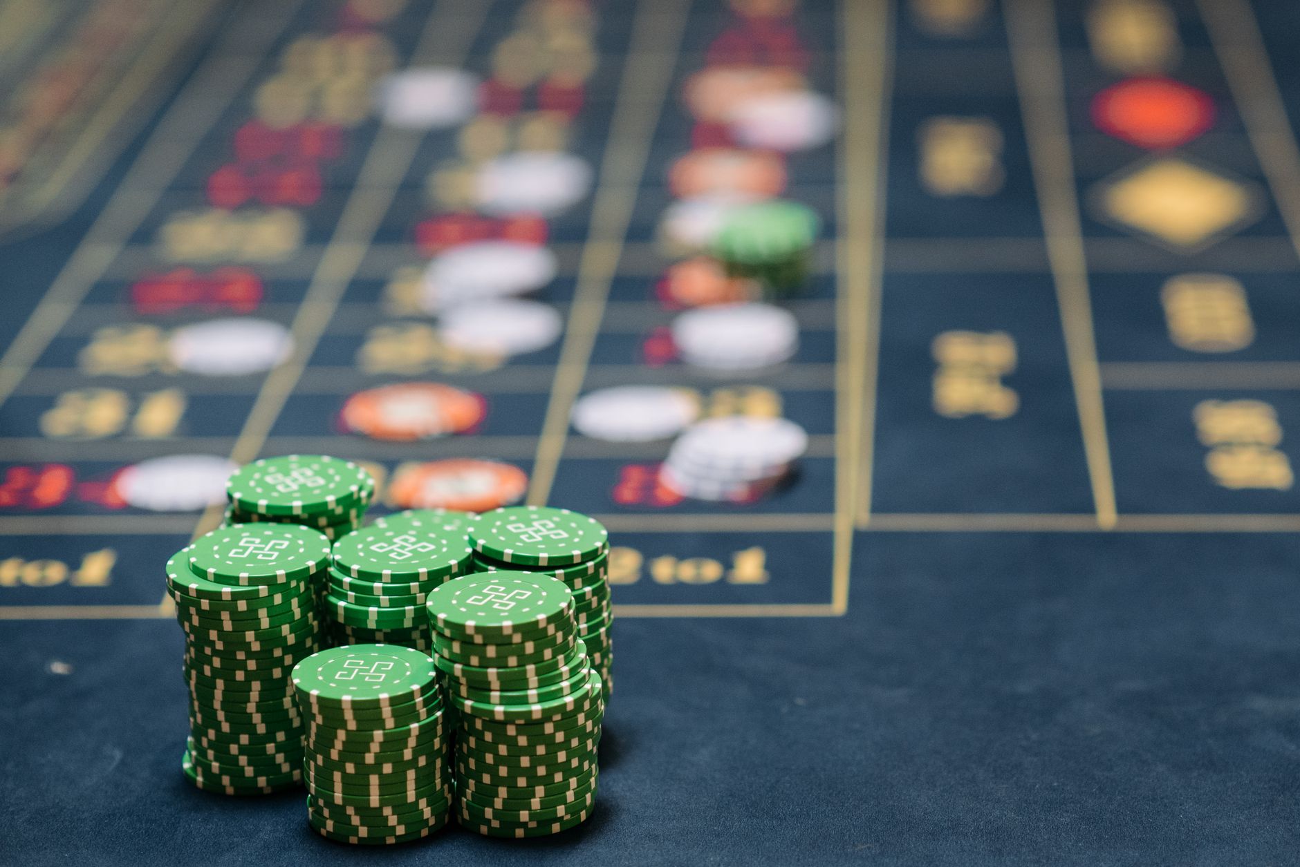 Stack of green poker chips on a casino table, highlighting the gambling theme. — The Rise of Live Dealer Games in Online Casi