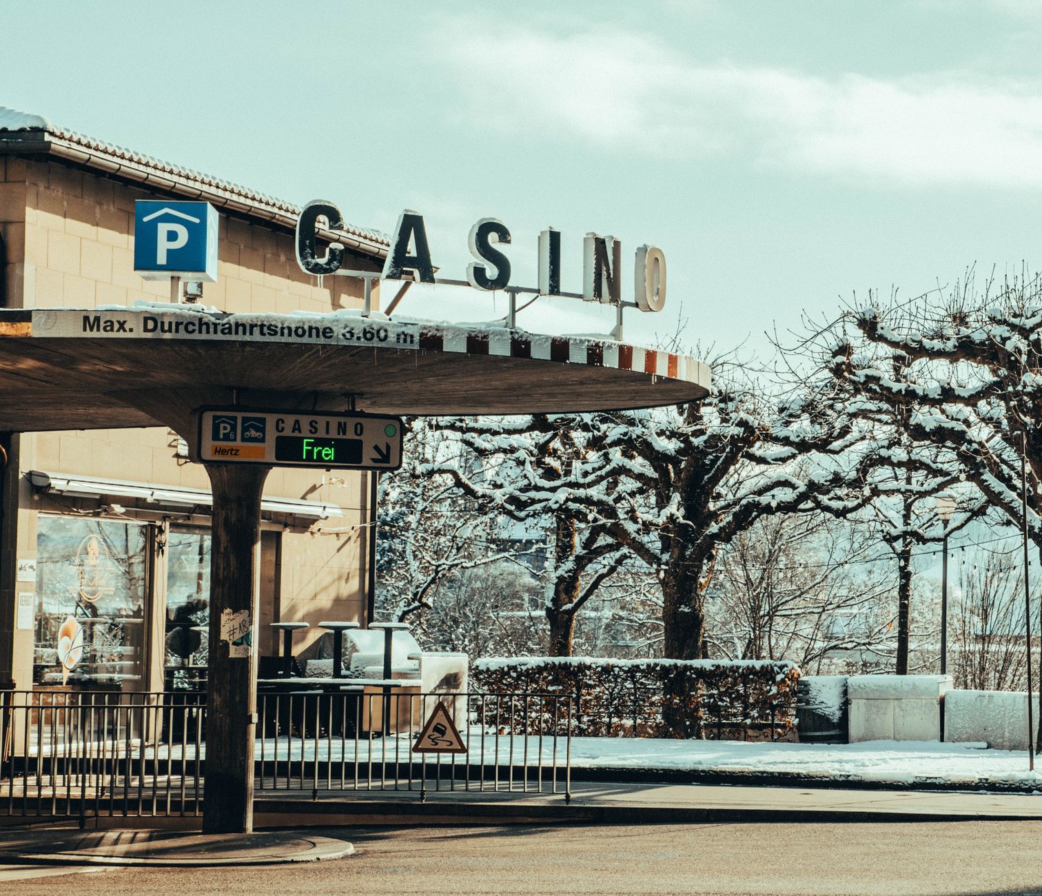 Winter scene of a casino entrance with snow-covered trees and parking sign — The Rise of Live Dealer Games in Online Casinos