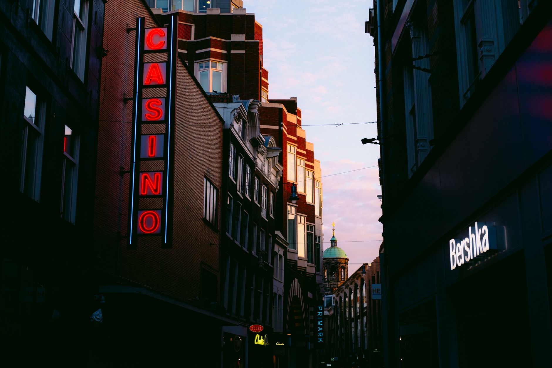 Urban cityscape at dusk featuring neon signs and illuminated streets, creating a lively atmosphere. — The Rise of Live Dealer