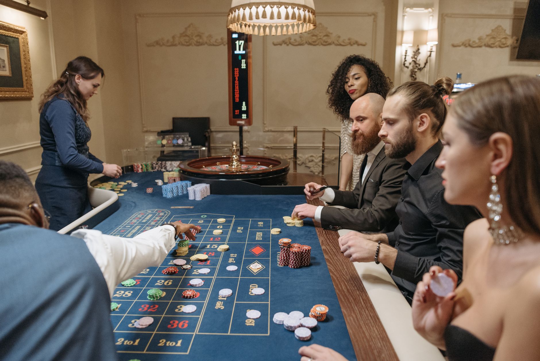 Diverse group enjoying a night of gambling at a luxurious casino roulette table. — The Rise of Mobile Casinos: Trends and Inn
