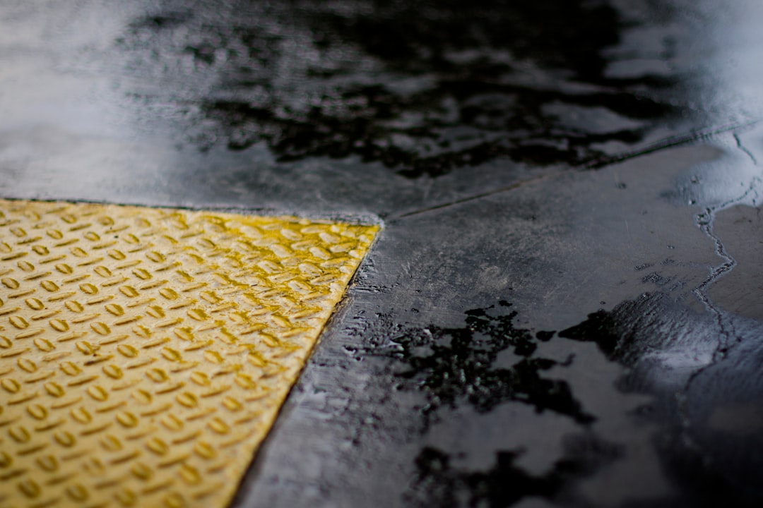 Close-up of a wet floor with a textured yellow safety mat